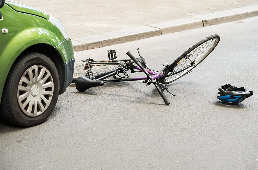 A bicycle and cycle helmet lay in the road following a collision with a car