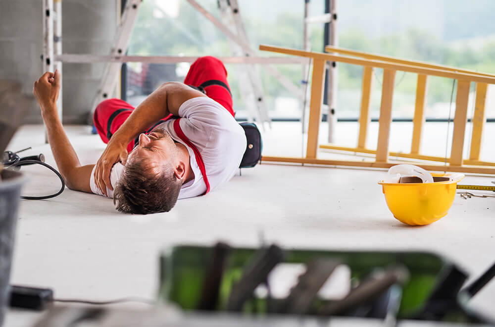 Man laying on the floor injured, after an accident on a building site