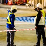 Factory workers point towards the scene of a factory accident