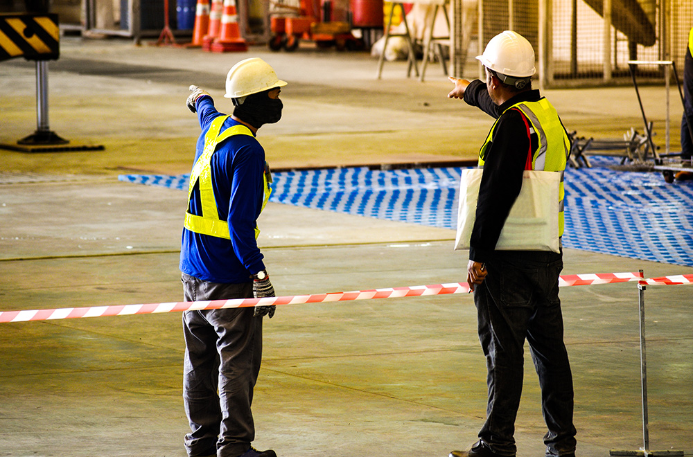 Factory workers point towards the scene of a factory accident