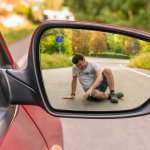 An injured pedestrian is visible a car's wing mirror