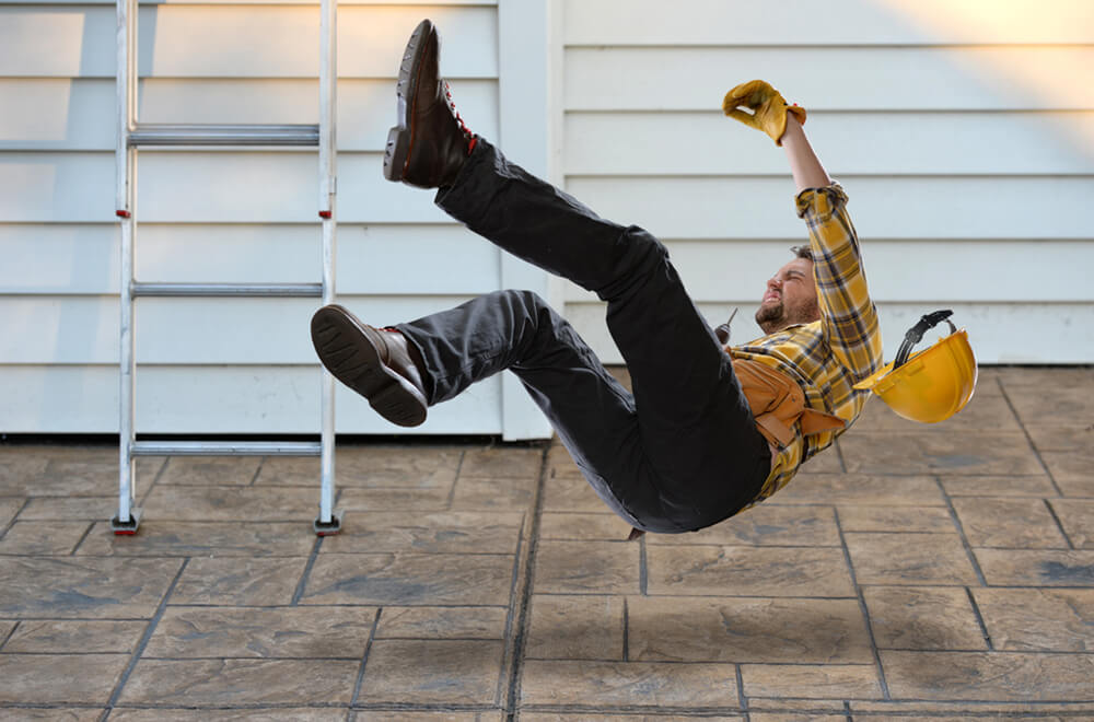 Male construction worker falling from a ladder in a workplace accident