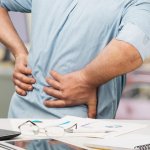 Man suffering back pain at work