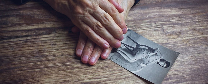 Women holding picture of younger self