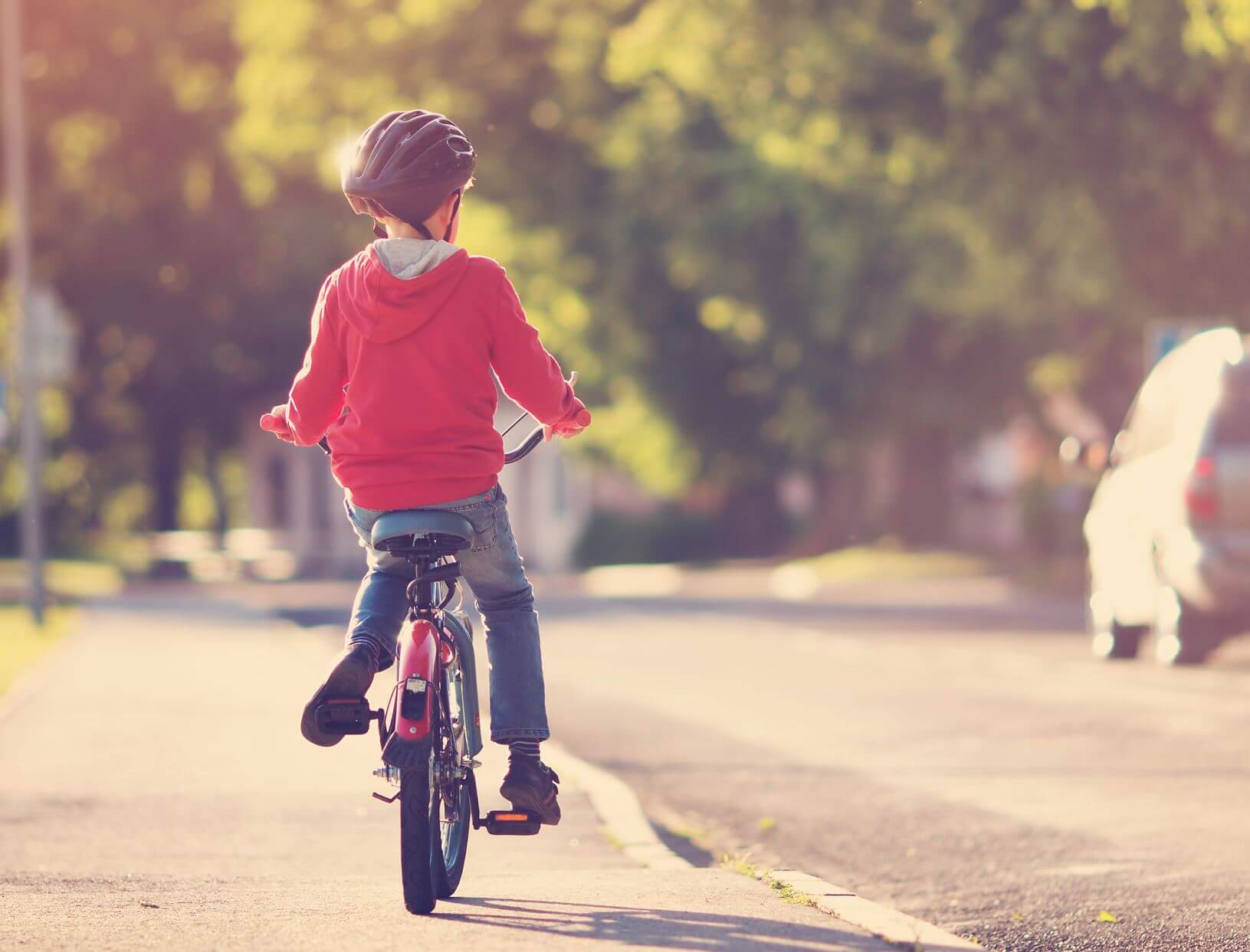 child on a bike near a road