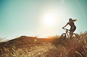 Woman cycling on a hillside in the sunshine