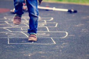 Child playing hopscotch in school playground