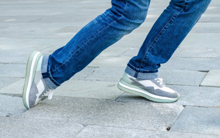 Close up of woman tripping on uneven paving stone.